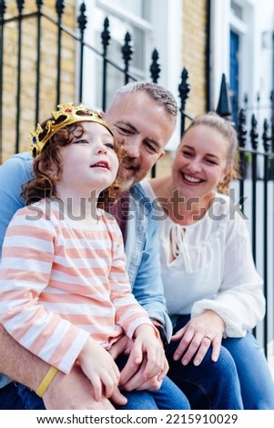Candid portrait of family sitting on front porch stairs.