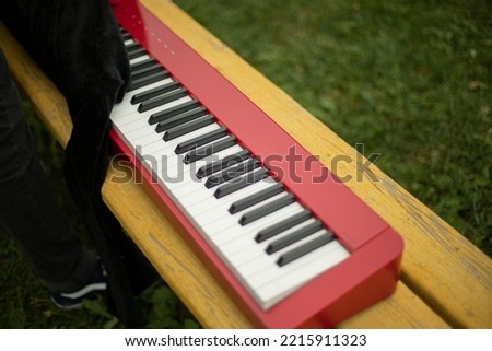 Red piano. Sound synthesizer. White keys. Electronic grand piano. Music equipment.