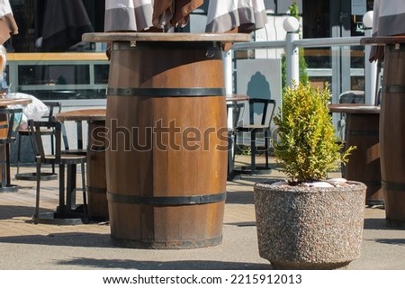 Barrels used as tables outside of a restaurant. Outdoor cafe. Design. Wood. Italy. Tourism. Travel. Wooden. Seat. Interior. Menu. Rustic. Exterior. Retro. Sidewalk. Urban. Italian. Vacation