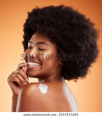 Cream, skincare and black woman excited about product for body against an orange studio background. Face of a young, happy and African model with smile for lotion or sunscreen for a healthy glow Royalty-Free Stock Photo #2215915685