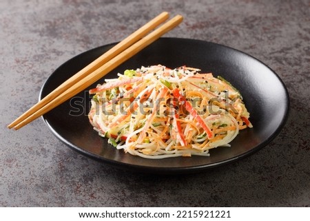 Kani salad made of crab meat and julienne vegetables, all doused in a sweet, spicy, and creamy dressing closeup in the plate on the table. Horizontal
 Royalty-Free Stock Photo #2215921221