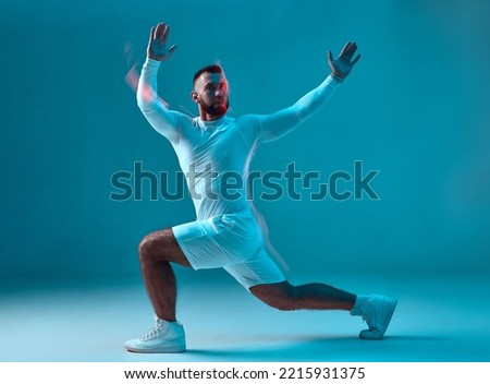 Fitness sport club advertising. Athletic guy training, does lunges exercise. Long exposure, motion blur. Burning workout Royalty-Free Stock Photo #2215931375