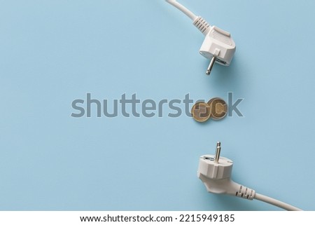 Coins with plugs on blue background. Heating season concept