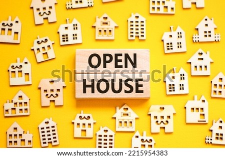 Open house symbol. Concept words 'Open house' on wooden blocks near miniature houses. Beautiful yellow background, copy space. Business and open house concept.
