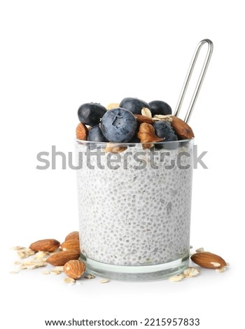 Glass of tasty chia seed pudding with berries and nuts on white background Royalty-Free Stock Photo #2215957833