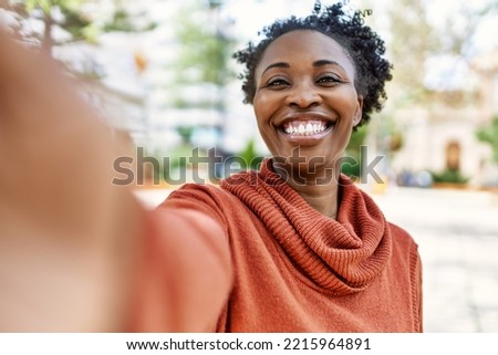 Young african american girl smiling happy make selfie by the smartphone at the city.