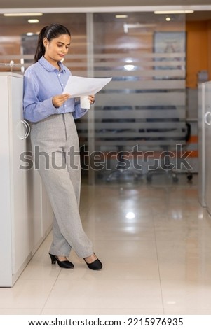  Indian business woman hold papers read document 