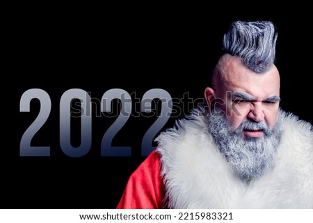 Evil aggressive gray-haired old man Santa in a bad mood. New Year and Christmas in the company of an unusual bad Santa. Severe dangerous Santa Claus with mohawk.