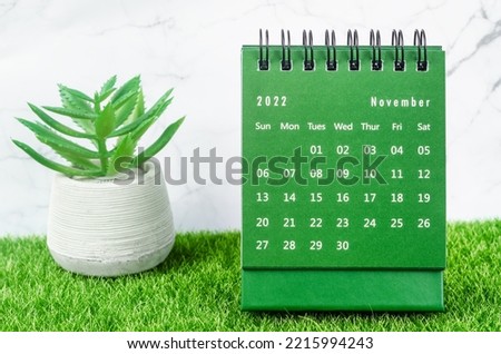 Green November 2022 Monthly desk calendar for 2022 year on grass.