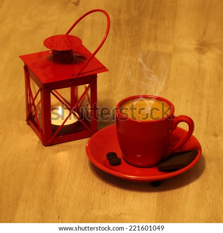Evening with hot coffee. Red cup coffee and  lantern on  wooden table  