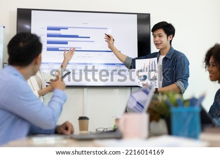 Professional marketer is making a presentation during a planning business meeting with colleagues. Meeting of diverse young entrepreneurs, talking, Businesspeople develop startup.