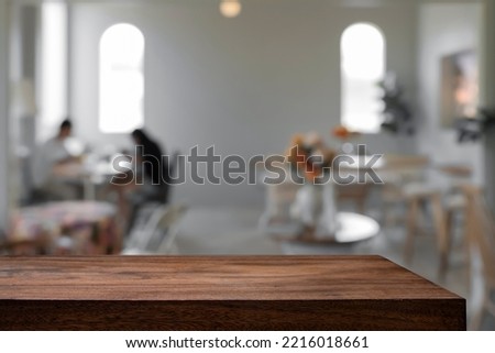 Empty wooden table with blurry background of cafe and coffee shop. For montage products.