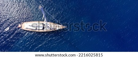 Aerial drone ultra wide panoramic photo with copy space of beautiful sail boat anchored in deep blue open ocean sea