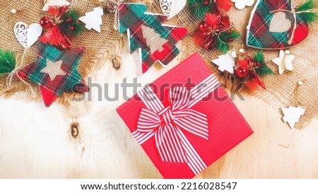 Christmas background with trees, stars and gift box. New Year decorations on wooden background. Flat lay, top view. 