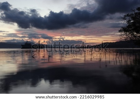 the reflection of the clouds seen at sunset and the sky turning orange, this beautiful landscape is seen in eastern Indonesia on the coast of the lattery village, Ambon city, Maluku province.
