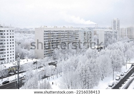 Urban winter landscape. A snow-covered city street, trees covered with snow. View from above. Cloudy winter day, soft light. Royalty-Free Stock Photo #2216038413
