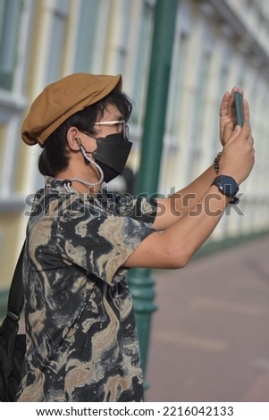 Asia Man With Phone, With Face-Mask...,Take Photographs..., Royalty-Free Stock Photo #2216042133