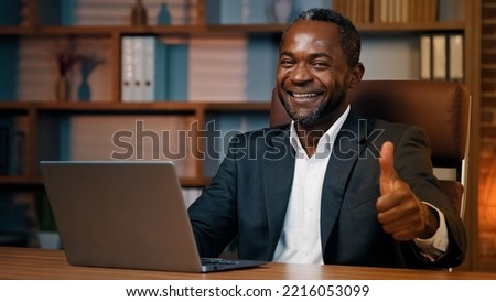 Focused man sitting at home office working on laptop successful businessman using new computer application for business tasks satisfied male customer showing thumb up gesture approval good result sign Royalty-Free Stock Photo #2216053099