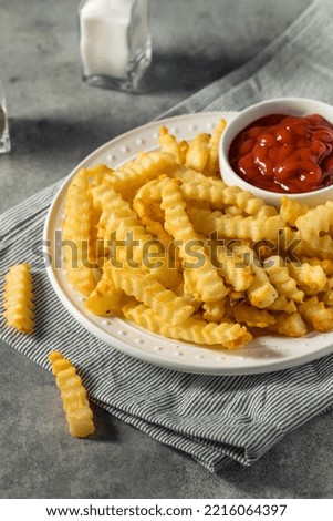 Homemade Crinkle Cut French Fries with Ketchup Royalty-Free Stock Photo #2216064397