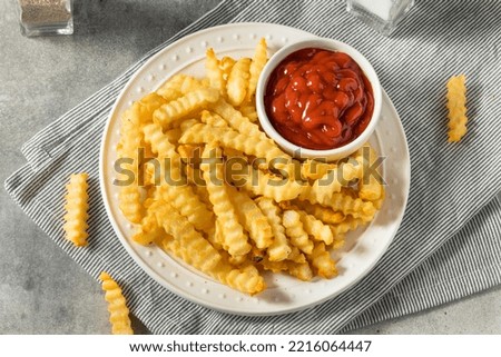 Homemade Crinkle Cut French Fries with Ketchup Royalty-Free Stock Photo #2216064447