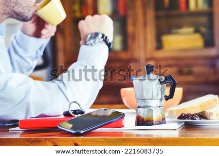 Old mocha coffee machine with businessman on background checking the time - Vintage coffeepot  on home table - Concept of business man at breakfast time ready for working day - Image