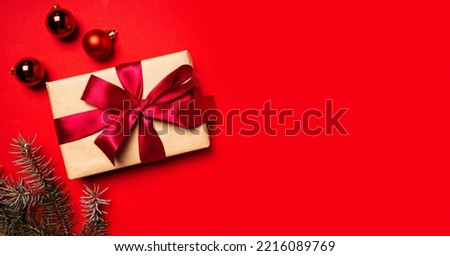 New Year banner concept white gift box and Christmas tree with red ribbon on red background