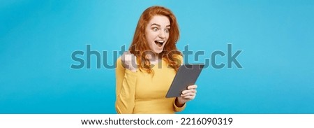 Close up Portrait young beautiful attractive redhair girl happy smiling on digital table with wining something. Blue Pastel Background. Copy space.