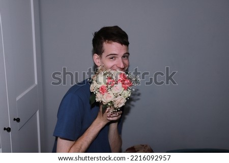 cute guy holding a bouquet of flowers in his hands