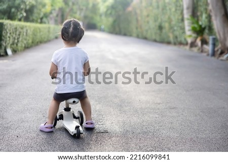 Back View of Asian Toddler Girl Ride a Bicycle