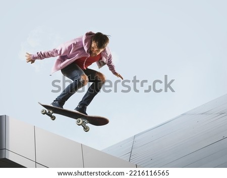 Skateboarder doing a jumping trick. Extreme sports concept on sky background