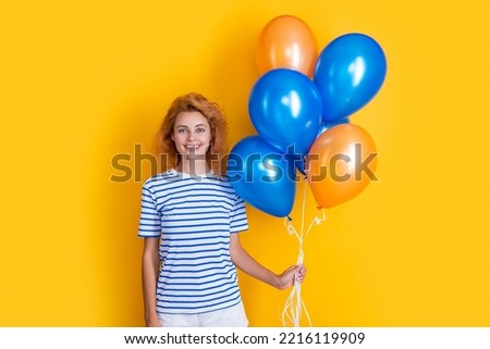 smiling woman hold party balloons in studio. woman with balloon for party isolated on yellow
