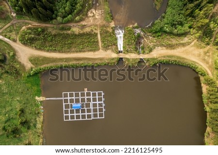 aerial view of a lake in the forest and a farm for growing fish, pantones on the water. photo from a drone on a forest lake