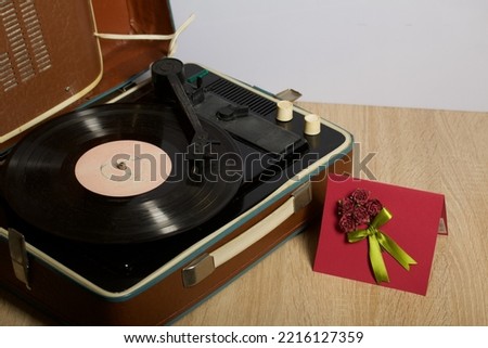 Vintage vinyl record player. Homemade greeting card. With decorative elements. Ribbons, flowers and leaves are attached to cardboard.