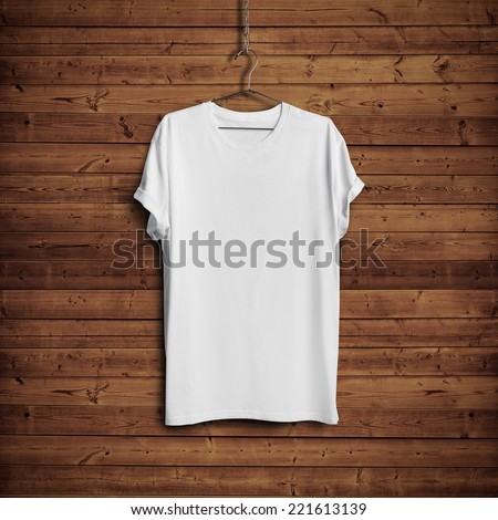 White blank t-shirt on dark wood wall Royalty-Free Stock Photo #221613139