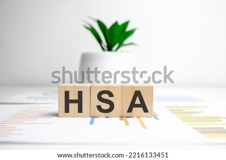 HSA - health savings account, text written on wooden blocks and charts Royalty-Free Stock Photo #2216133451