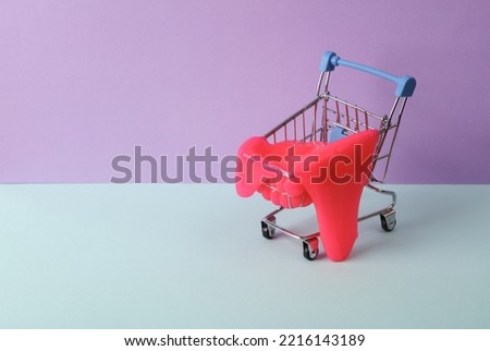 Creative layout, Shopping trolley with neon slime on two tone pastel background. Visual trend. Minimalistic aesthetic still life. Fresh idea
