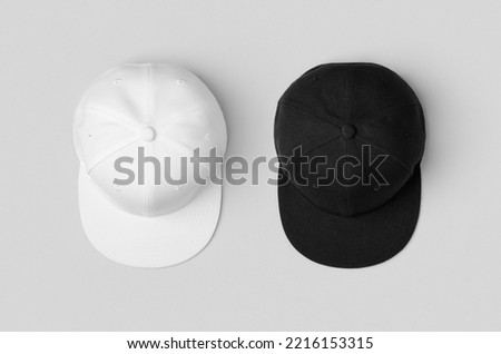 White and black snapback caps mockup, side by side. Royalty-Free Stock Photo #2216153315