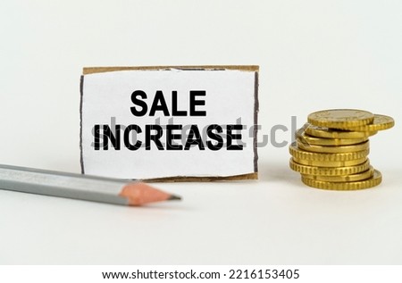 Business concept. On a white background, a pencil, coins and a sign with the inscription - SALE INCREASE