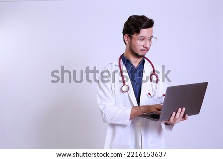 Doctor doing some work using laptop on a studio background