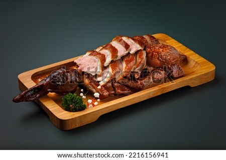 Roasted Chinese duck.  Sliced and presented on a wooden board. Traditional and delicious Asian dish. The duck is served pink. Juicy and tender looking meat.