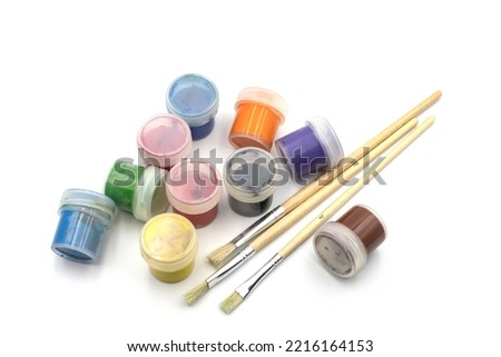 Set of watercolor paints and paintbrushes for painting closeup on a white background. Selective focus. A set of paints for drawing