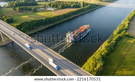 Cargo ships and motorway bridge. Traffic on the A 7 federal motorway and Kiel Canal. Infrastructure and transportation of goods. Intermodal transport-concept. Shipping and transportation of goods. Royalty-Free Stock Photo #2216170531