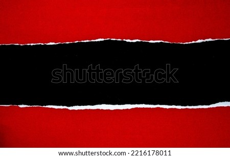 Red torn paper on black background with copy space. Royalty-Free Stock Photo #2216178011