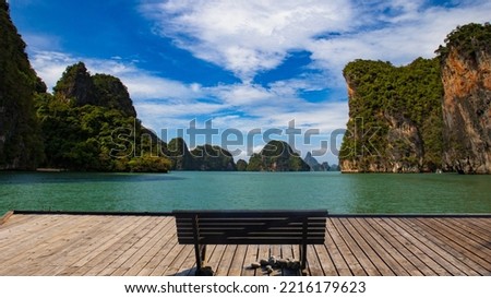 Thailand nature. Lakes in Phuket. Bench on wooden pier. Met with view of nature of Thailand. Summer landscape. Rocks with trees in middle of lake. Travel to Thailand. Bench overlooking landscape Royalty-Free Stock Photo #2216179623