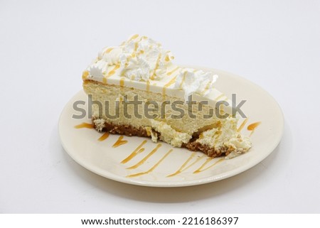 PICTURE OF A SLICE OF CHEESECAKE. TAKEN ON A WHITE BACKGROUND.