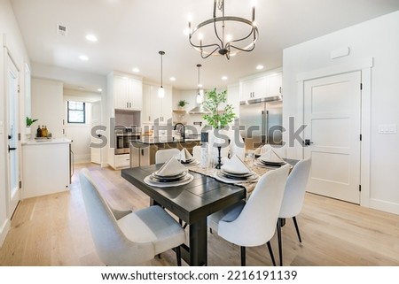 interior kitchen and dining room with high end appliances table with setting white counter and cabinets Royalty-Free Stock Photo #2216191139
