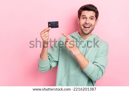 Photo of positive man indicate finger hand hold debit card isolated on pink color background