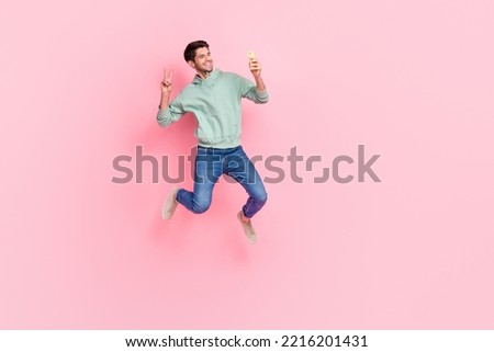 Full length photo of attractive cheerful blogger user make video record self portrait v-sign empty space isolated on pink color background