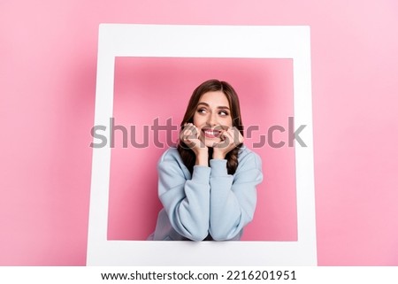 Portrait of cute cheerful lady hands touch cheeks look empty space paper album card isolated on pink color background
