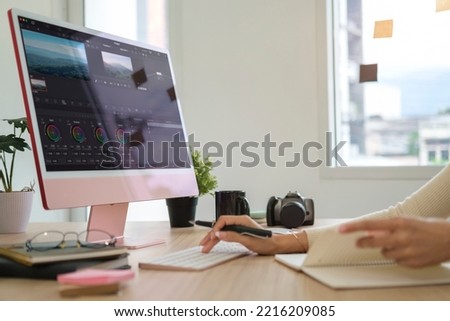 Close up view of videographer  editing video footage on professional computer at her workstation.